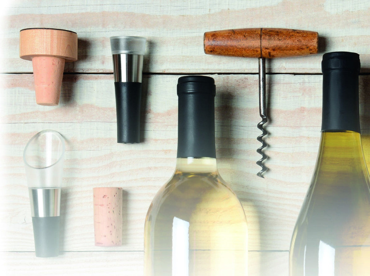 Bouchons, bouchon verseur et tire-bouchon posés sur du bois blanc
