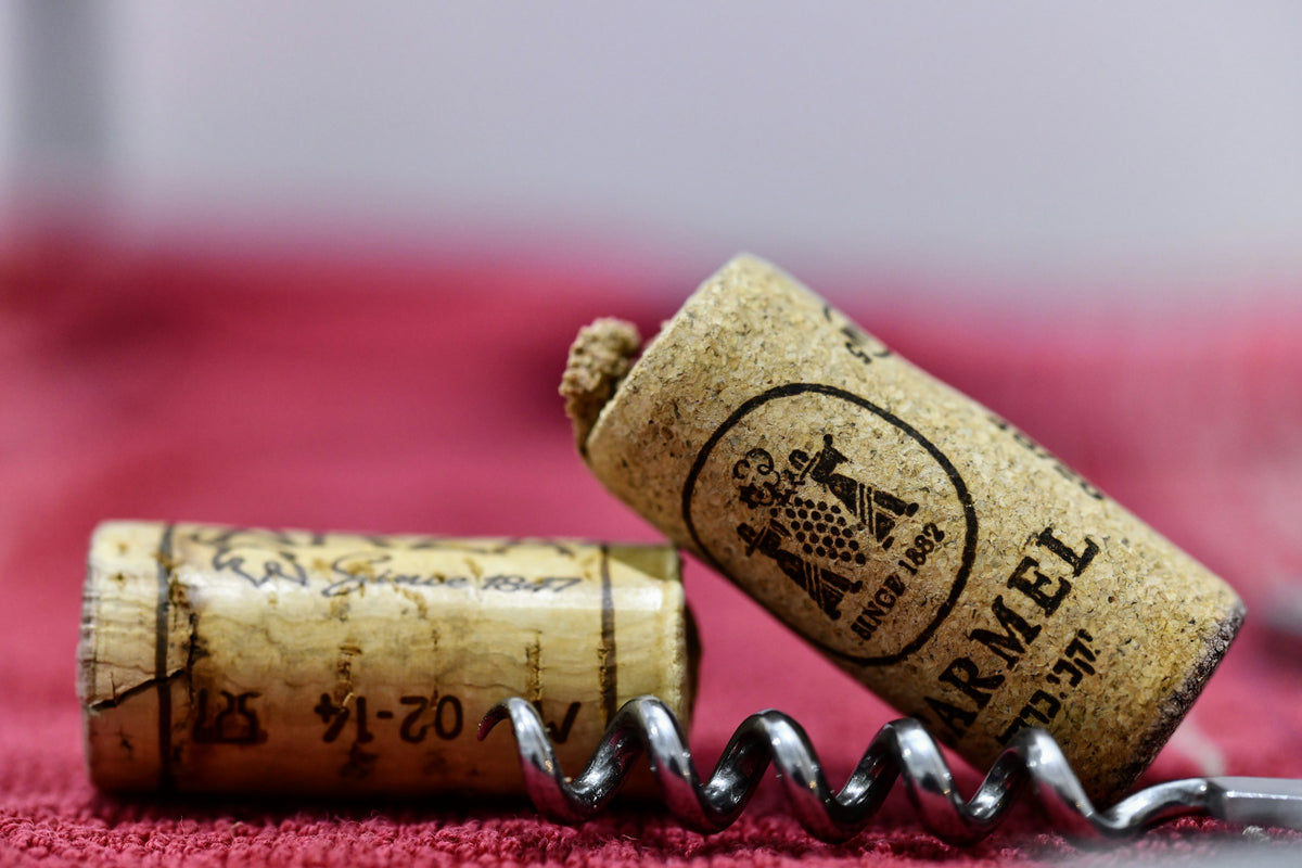 Bouchons de liège et tire-bouchon sommelier sur une nappe rouge
